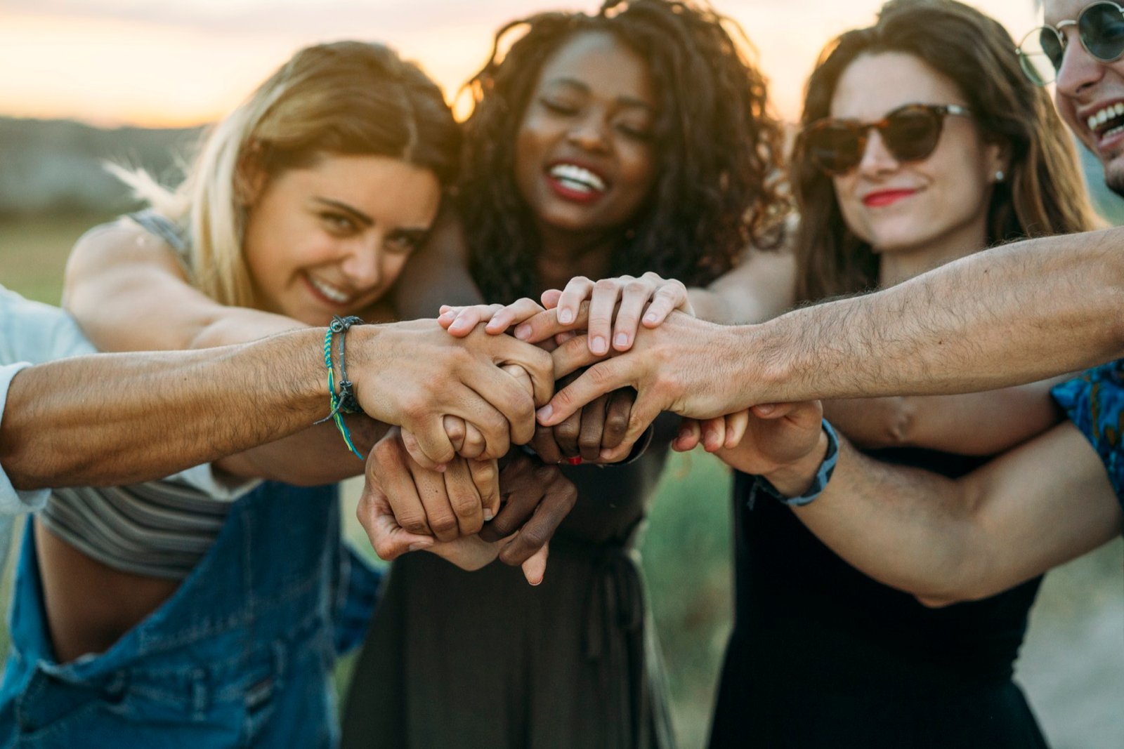 A group of friends together outdoors at sunset